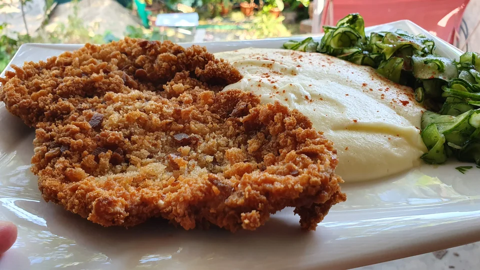 Snitel din cotlet de porc, piure de cartofi şi salată de castraveţi